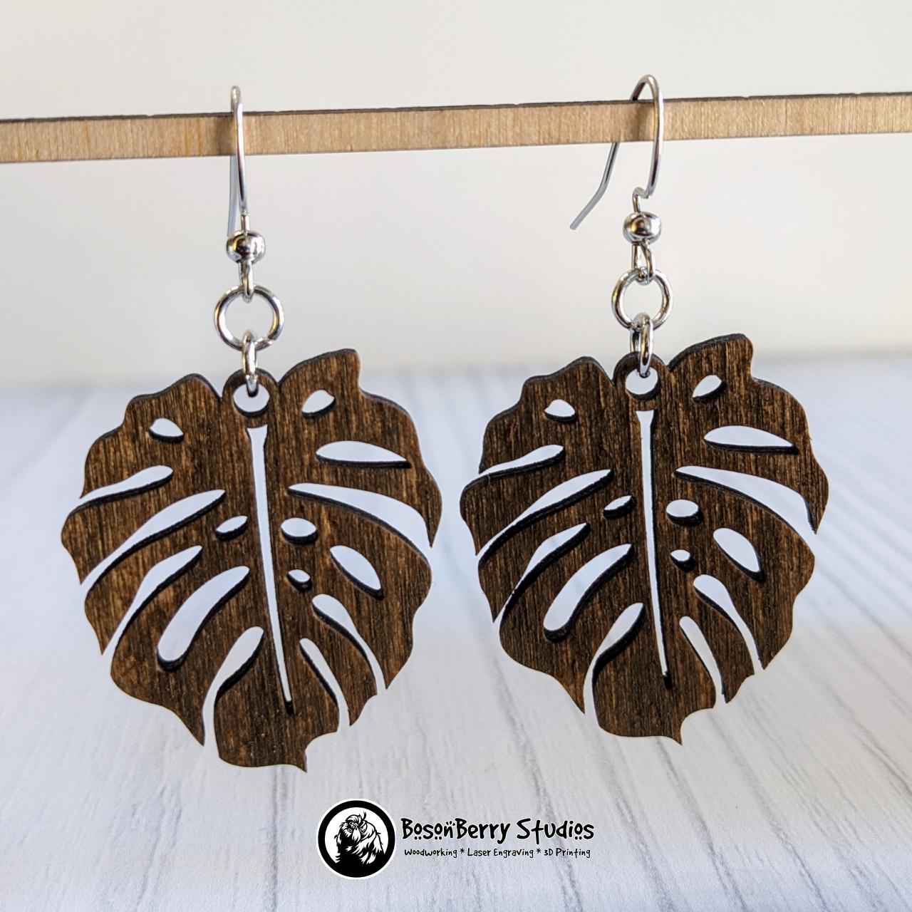 Monstera Leaf Wooden Earrings: suspended over white background