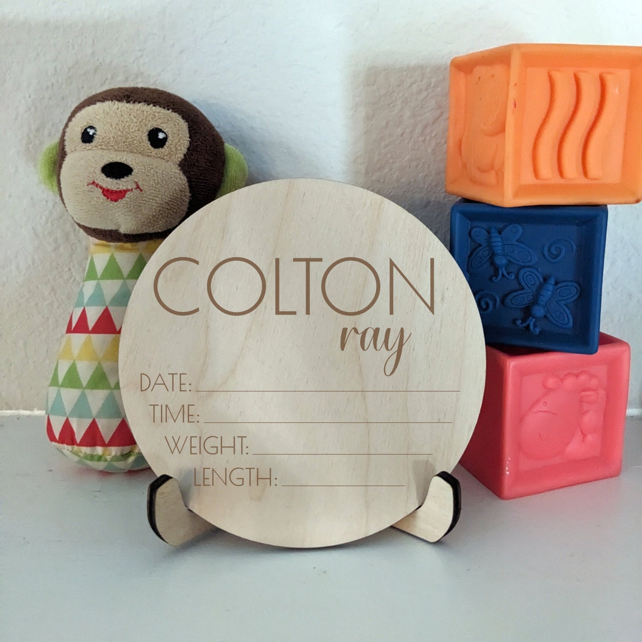 A sign for newborn stats with toys in the background