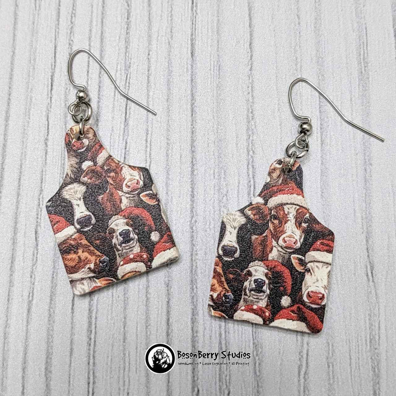 Cow-tag shaped Christmas Cows Acrylic Earrings on a white background.