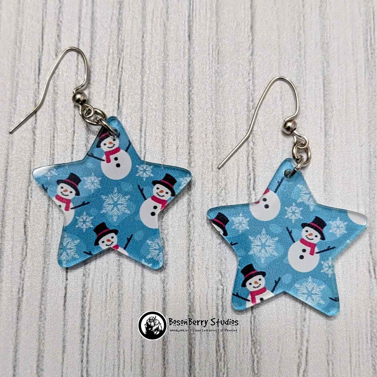 Star-shaped Blue Snowmen Acrylic Earrings on white background.