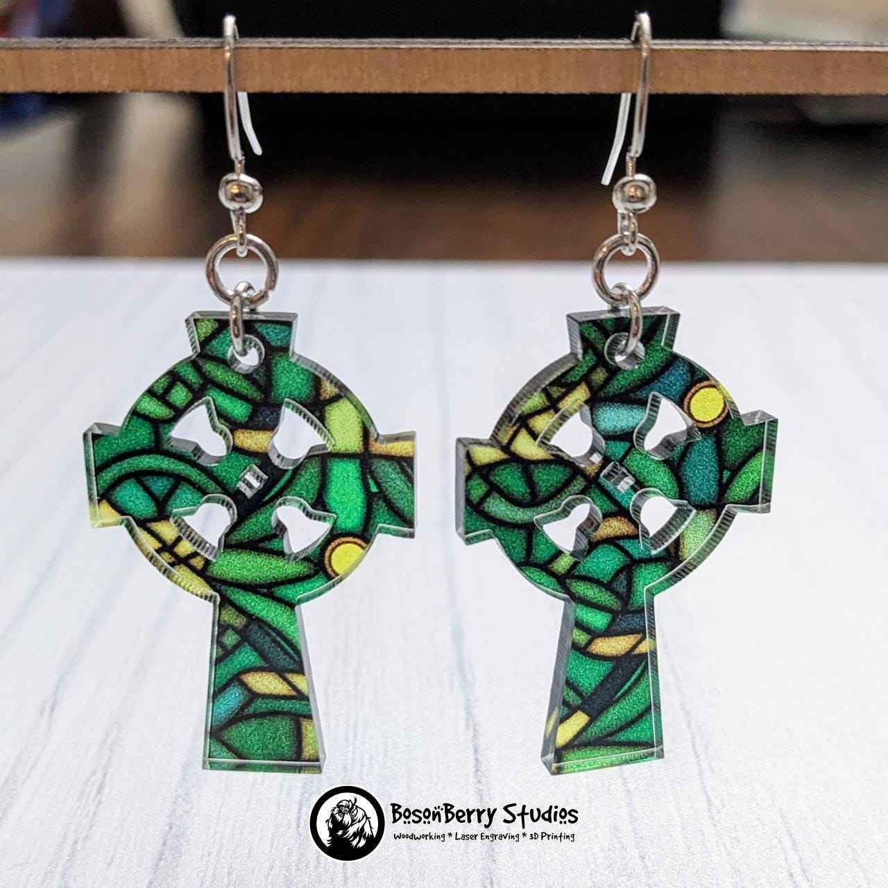 Celtic Stained Glass Acrylic Earrings: celtic cross shaped hanging in front of white background