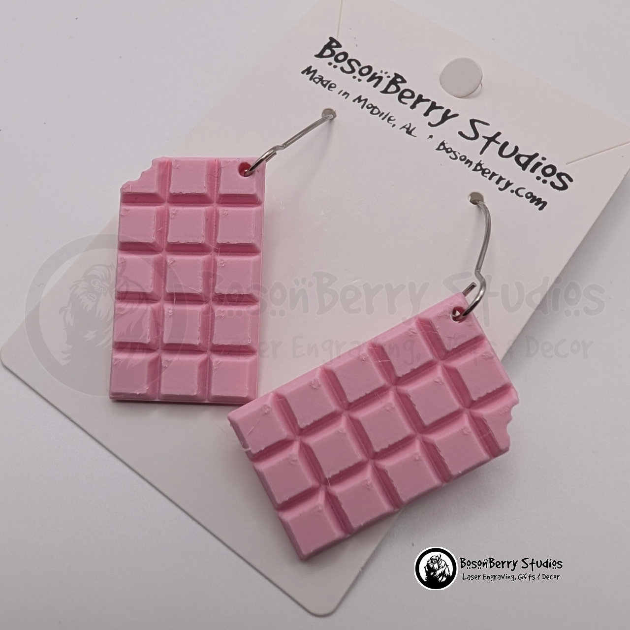 Set of pink chocolate bar-shaped earrings on cards with 'BosonBerry Studios' branding.