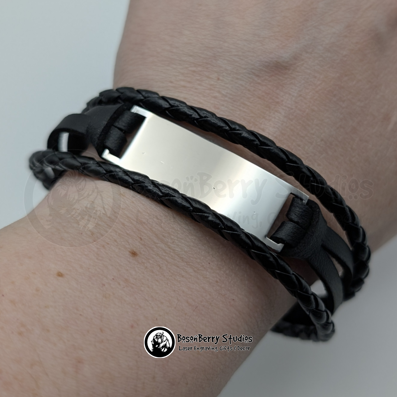 Black braided triple cord and silver metal bracelet on a wrist with a white background and 'BosonBerry Studios' branding.