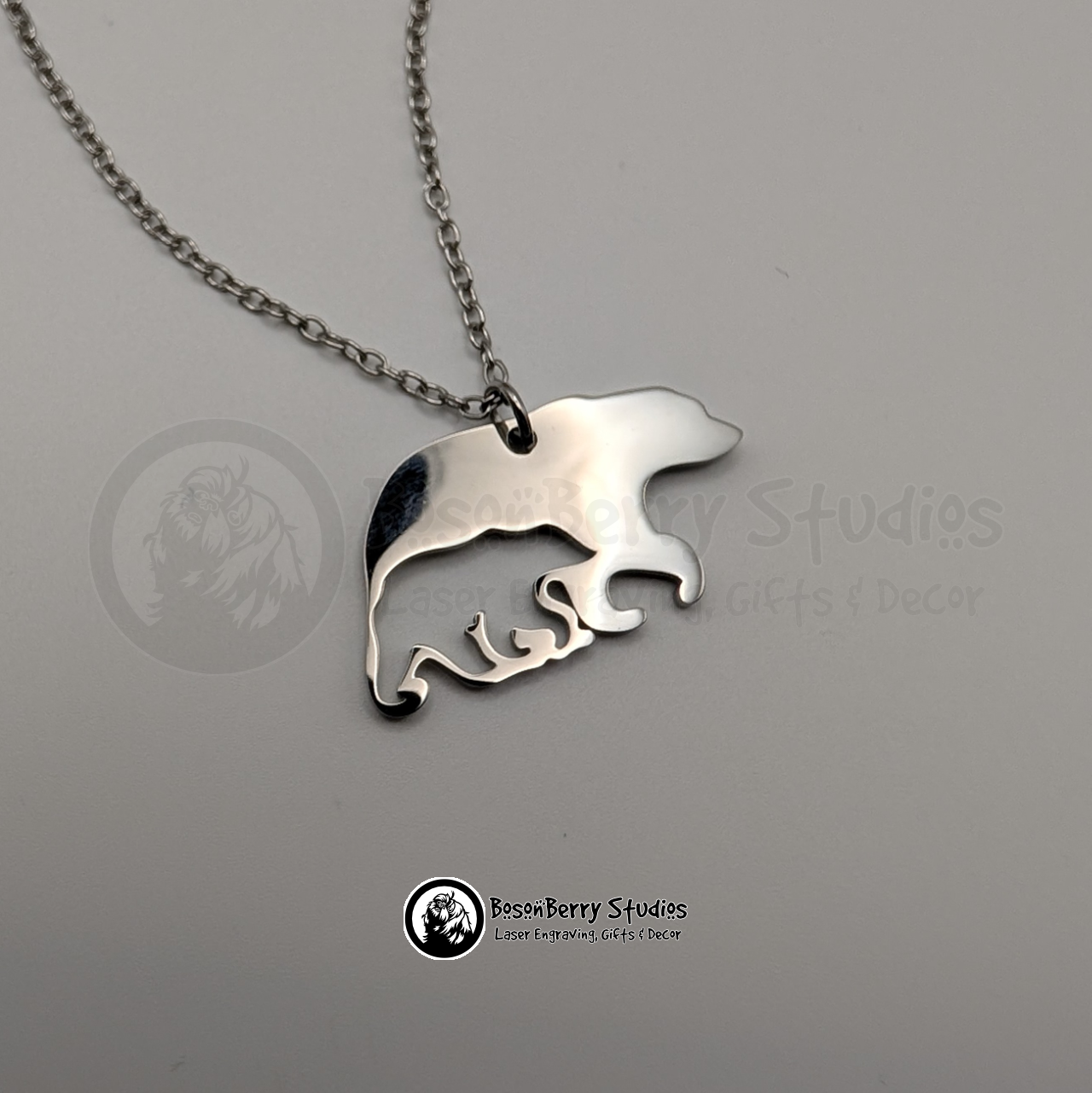 A silver bear-shaped pendant necklace with cub-shaped cutout on a white background with 'BosonBerry Studios' branding.