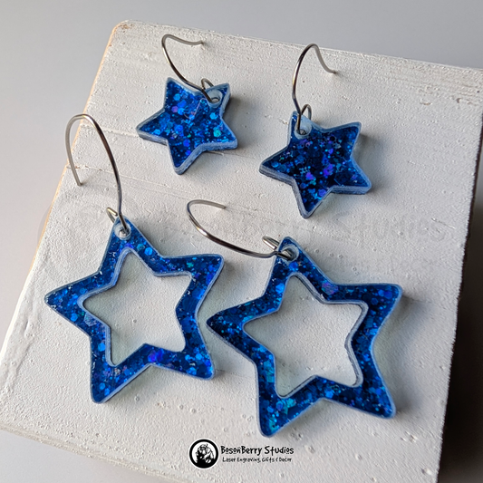 Star-shaped blue glitter earrings on a white background, branded 'BosonBerry Studios'.