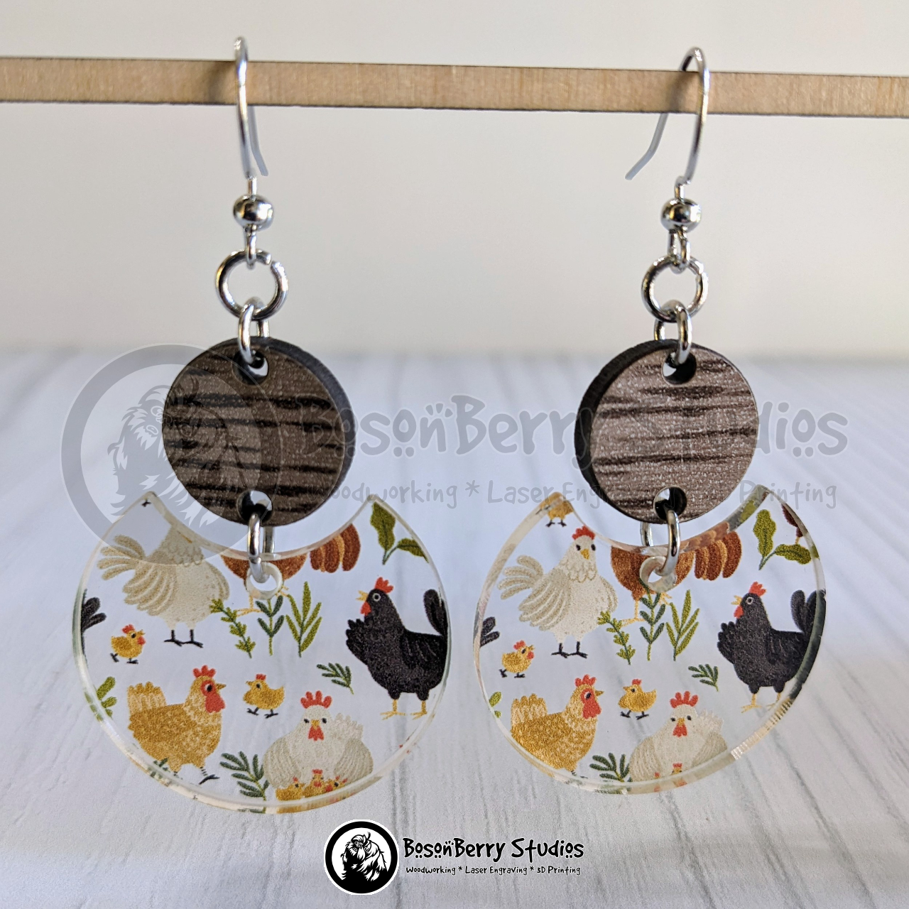 Rounded Scattered Chickens Clear Acrylic Earrings  with wooden connectors suspended over a white background