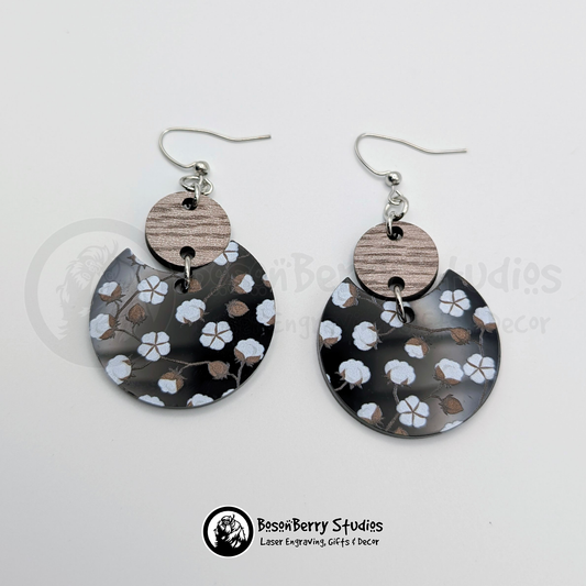 Black acrylic earrings with a cotton pattern, disc shaped with a wooden connector, on a white background with 'BosonBerry Studios' branding. 