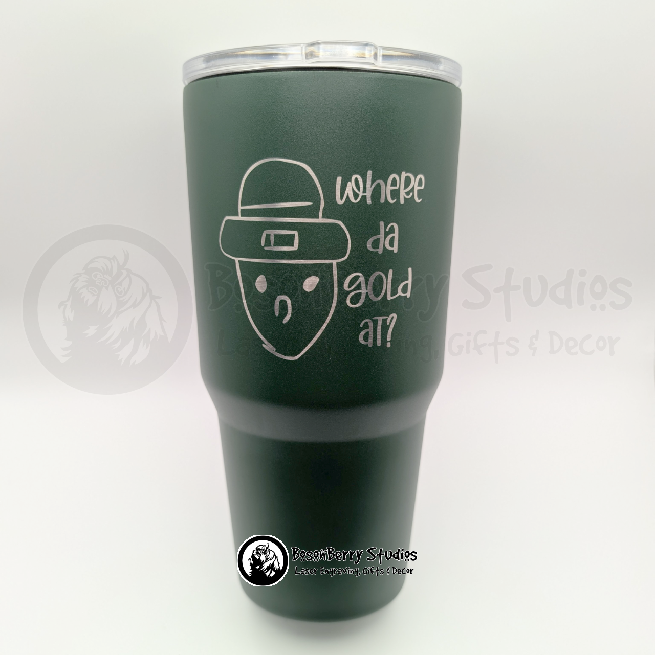 Green travel mug engraved with the Crichton Leprechaun and text on a white background