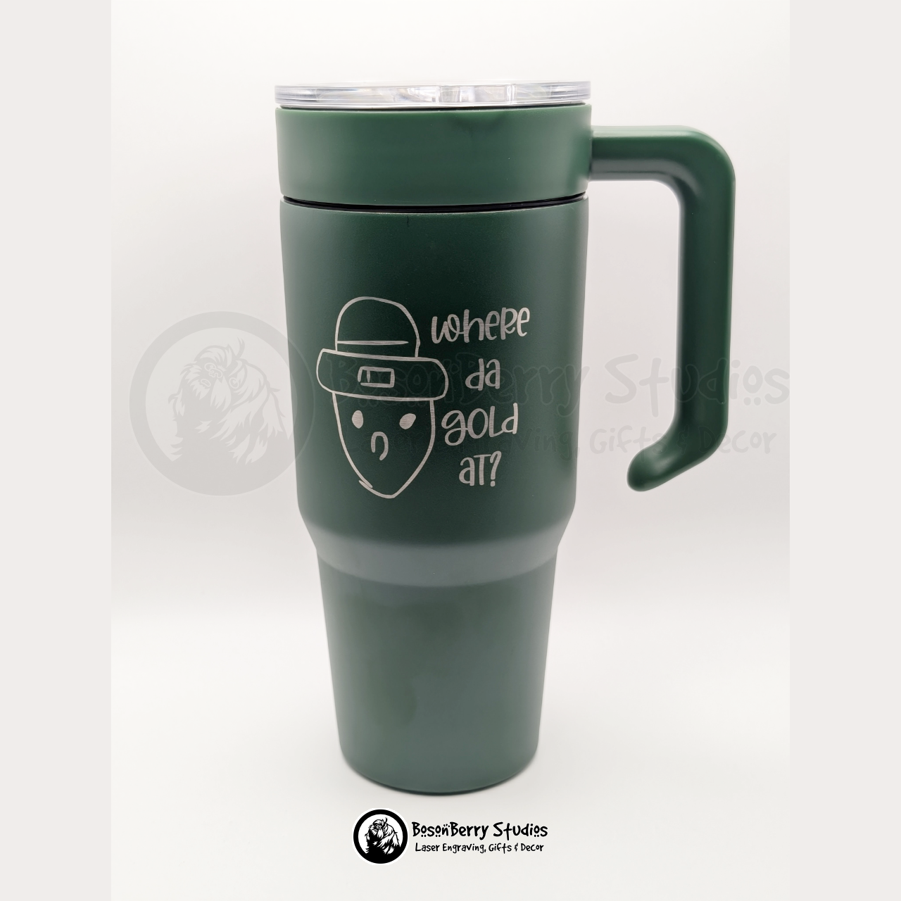 Green travel mug with a handle engraved with the Crichton Leprechaun and text on a white background
