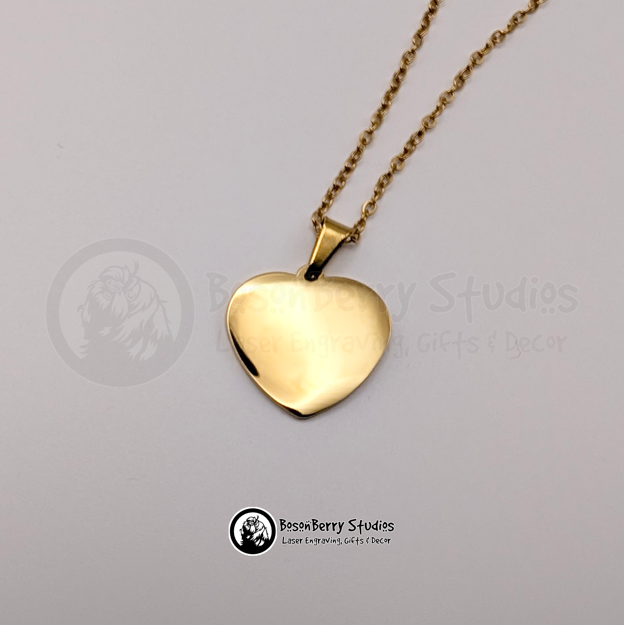 Gold heart-shaped pendant necklace on a white background with 'BosonBerry Studios' branding.