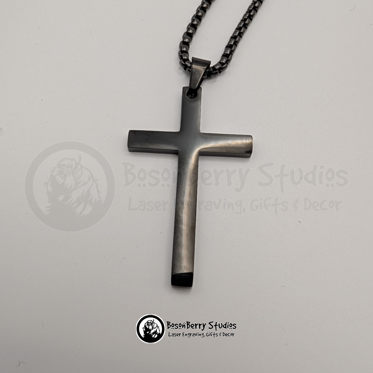 Black large cross pendant necklace on a white background with 'BosonBerry Studios' branding.