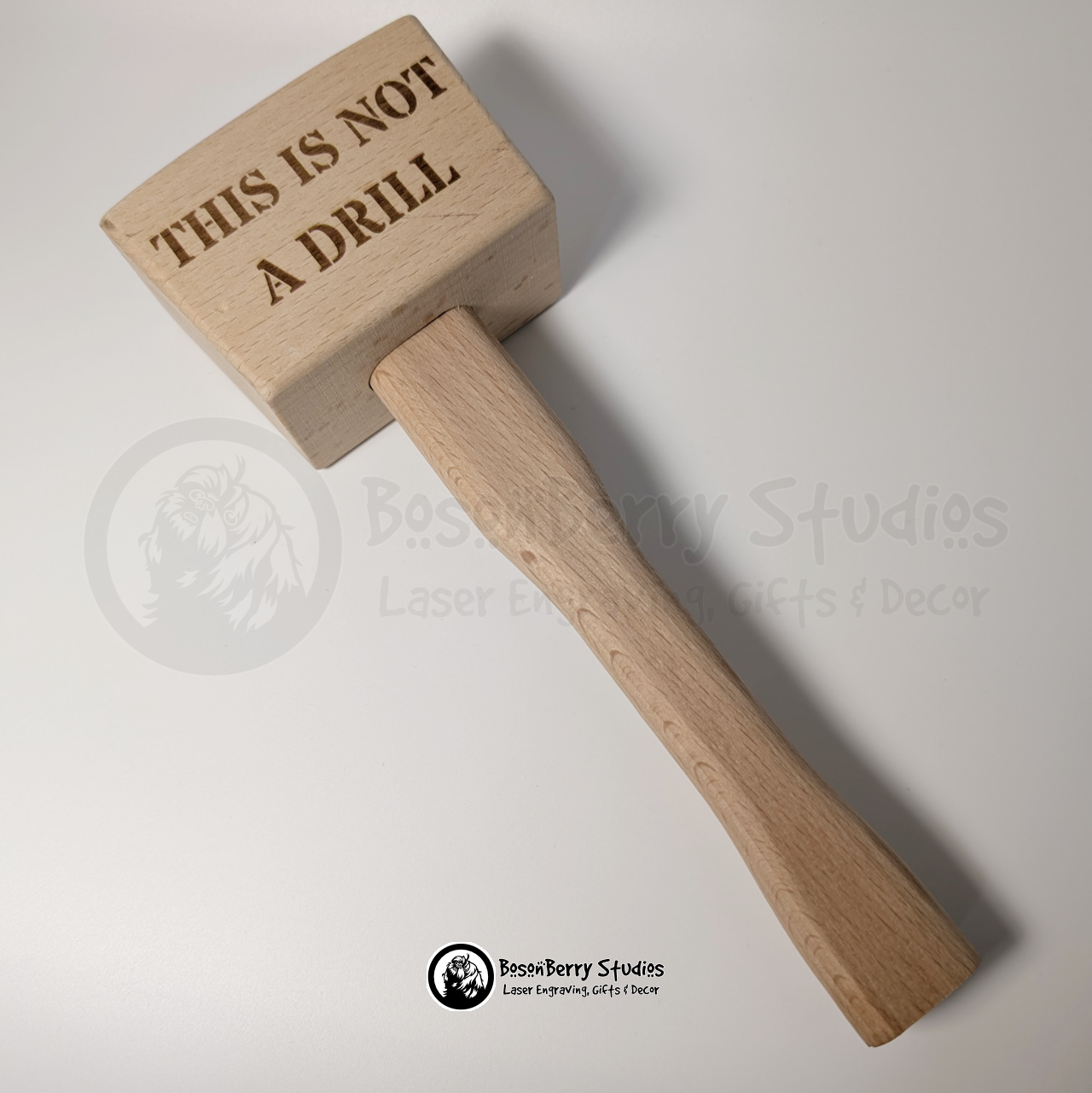 Wooden mallet engraved with 'THIS IS NOT A DRILL' text on a light background