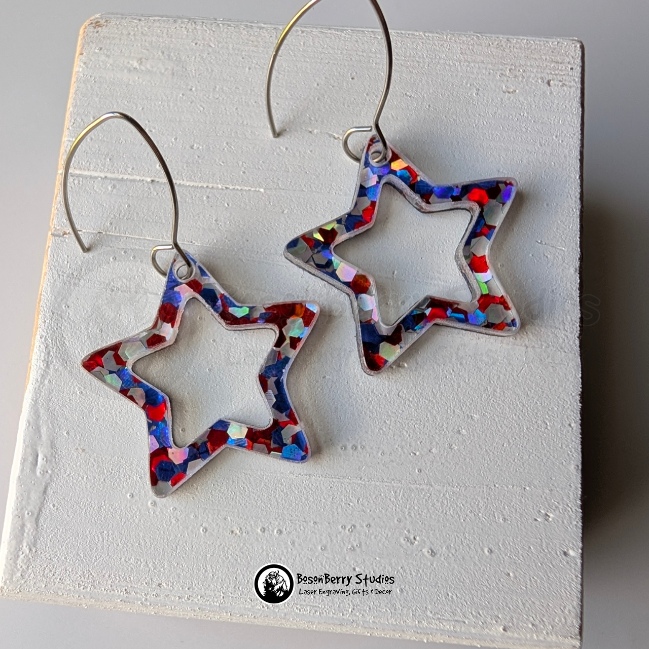 Star-shaped red white and blue glitter earrings on a white background, branded 'BosonBerry Studios'.