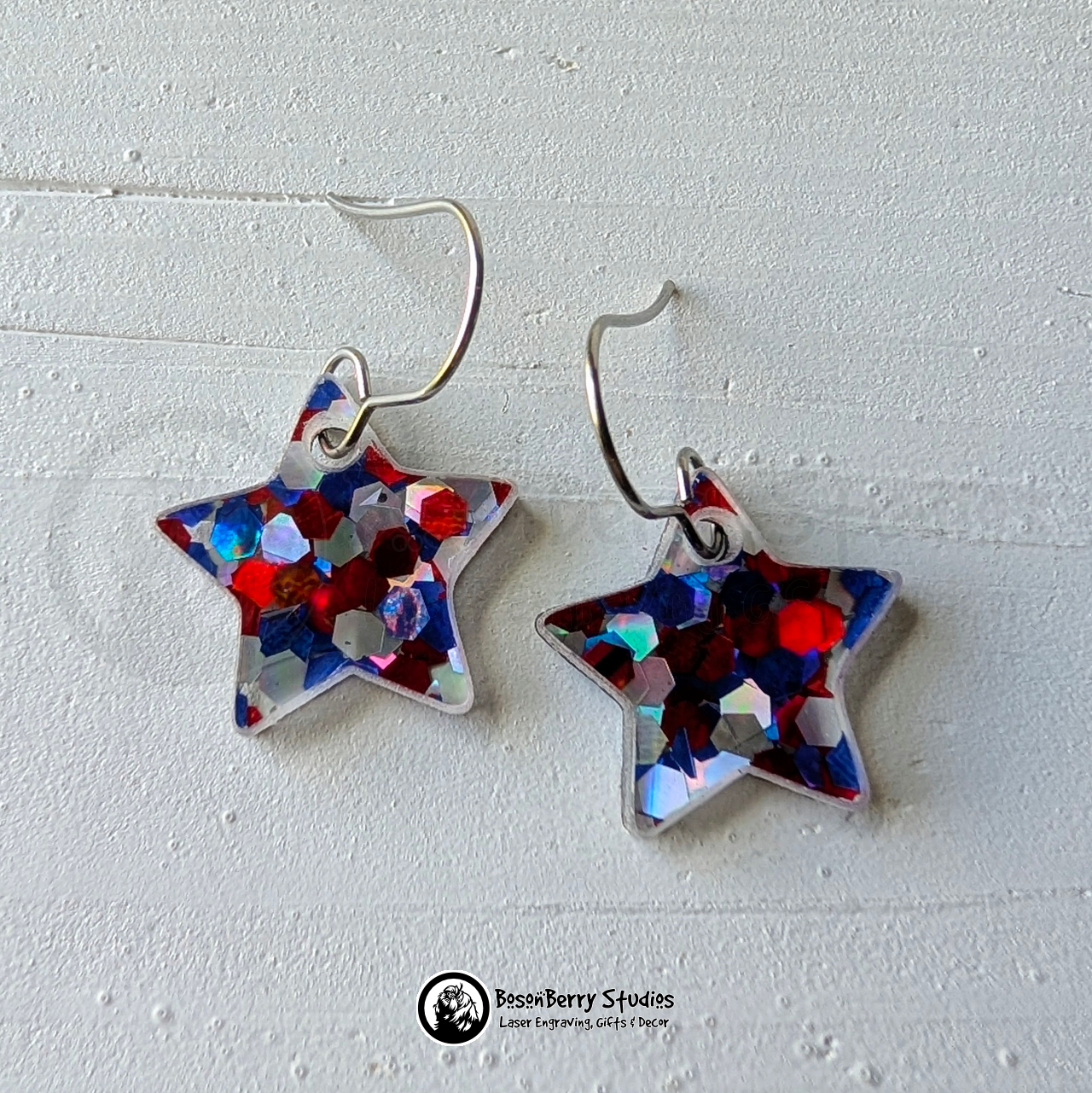 Star-shaped red white and blue glitter earrings on a white background, branded 'BosonBerry Studios'.