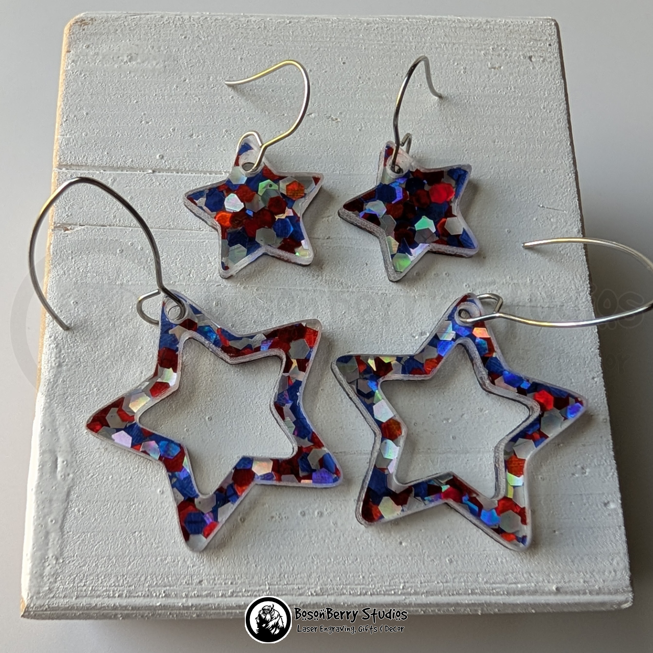 Star-shaped red white and blue glitter earrings on a white background, branded 'BosonBerry Studios'.