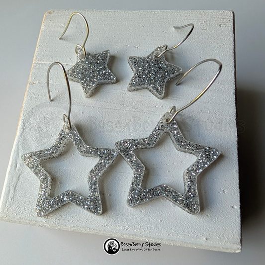 Star-shaped silver glitter earrings on a white background, branded 'BosonBerry Studios'.