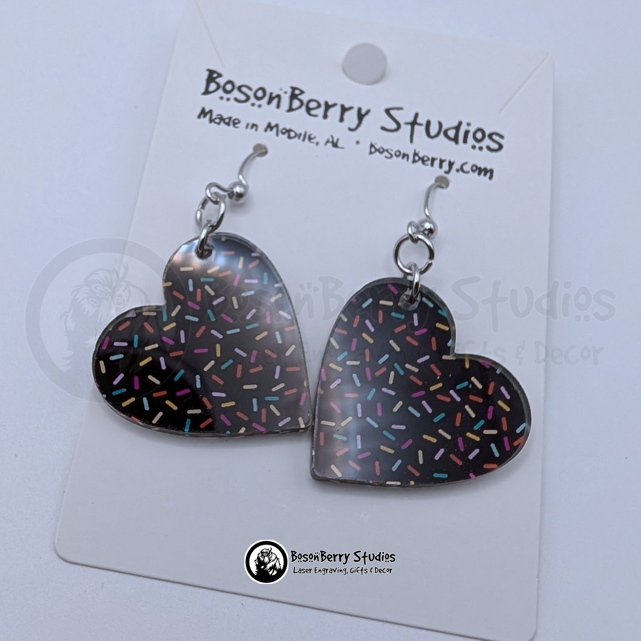 Chocolate heart-shaped earrings with a colorful sprinkles pattern, on cards with BosonBerry Studios branding.