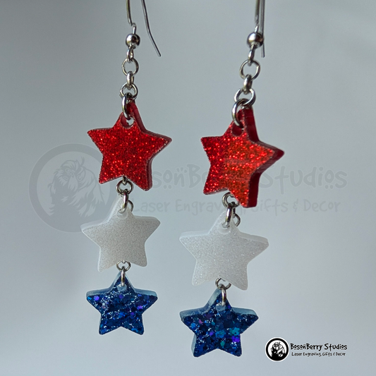 Star-shaped earrings in red, white, and blue on a white background with "BosonBerry Studios" branding.