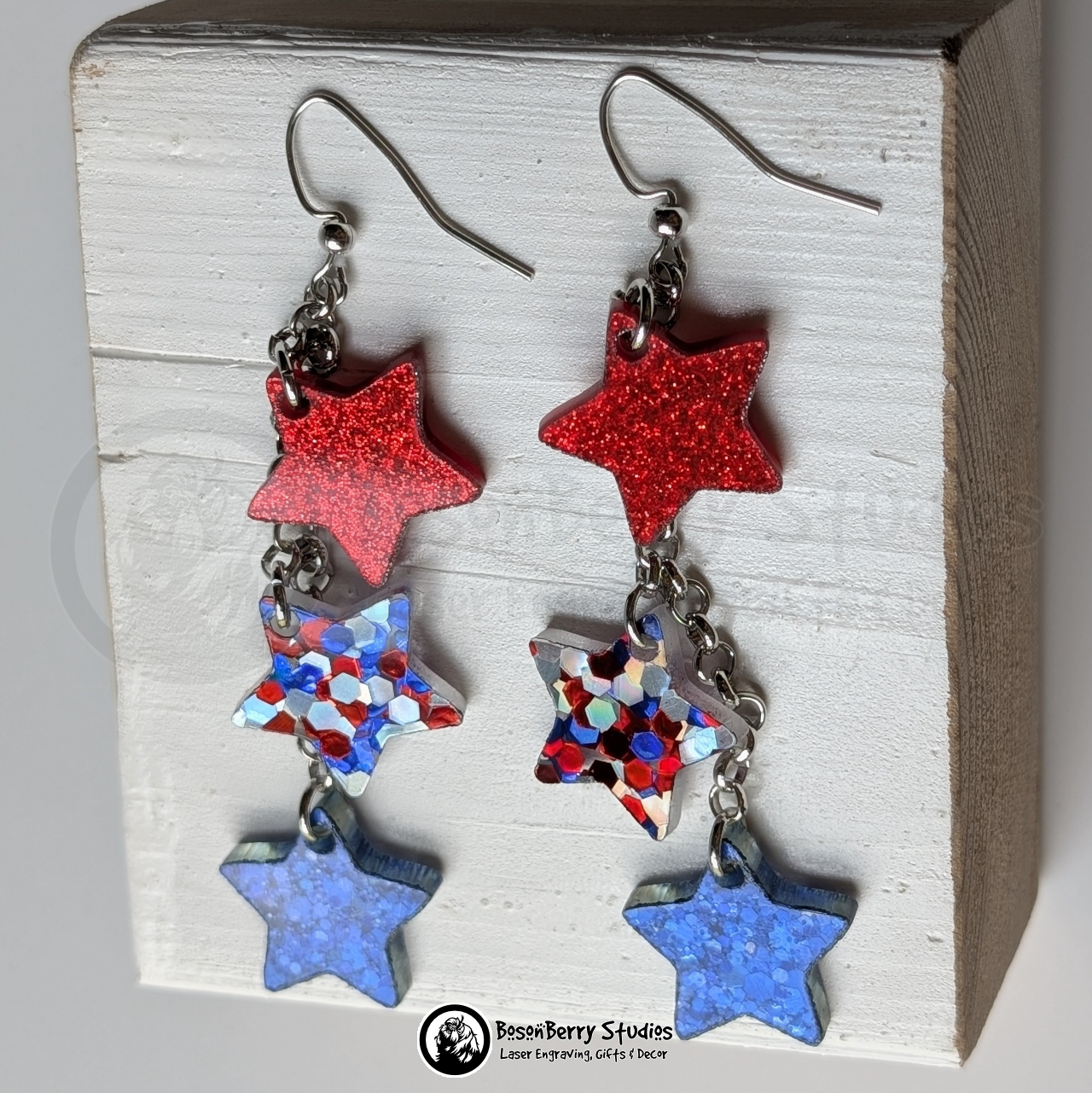 Star-shaped earrings in red, red-silver-blue, and blue on a white background with "BosonBerry Studios" branding.