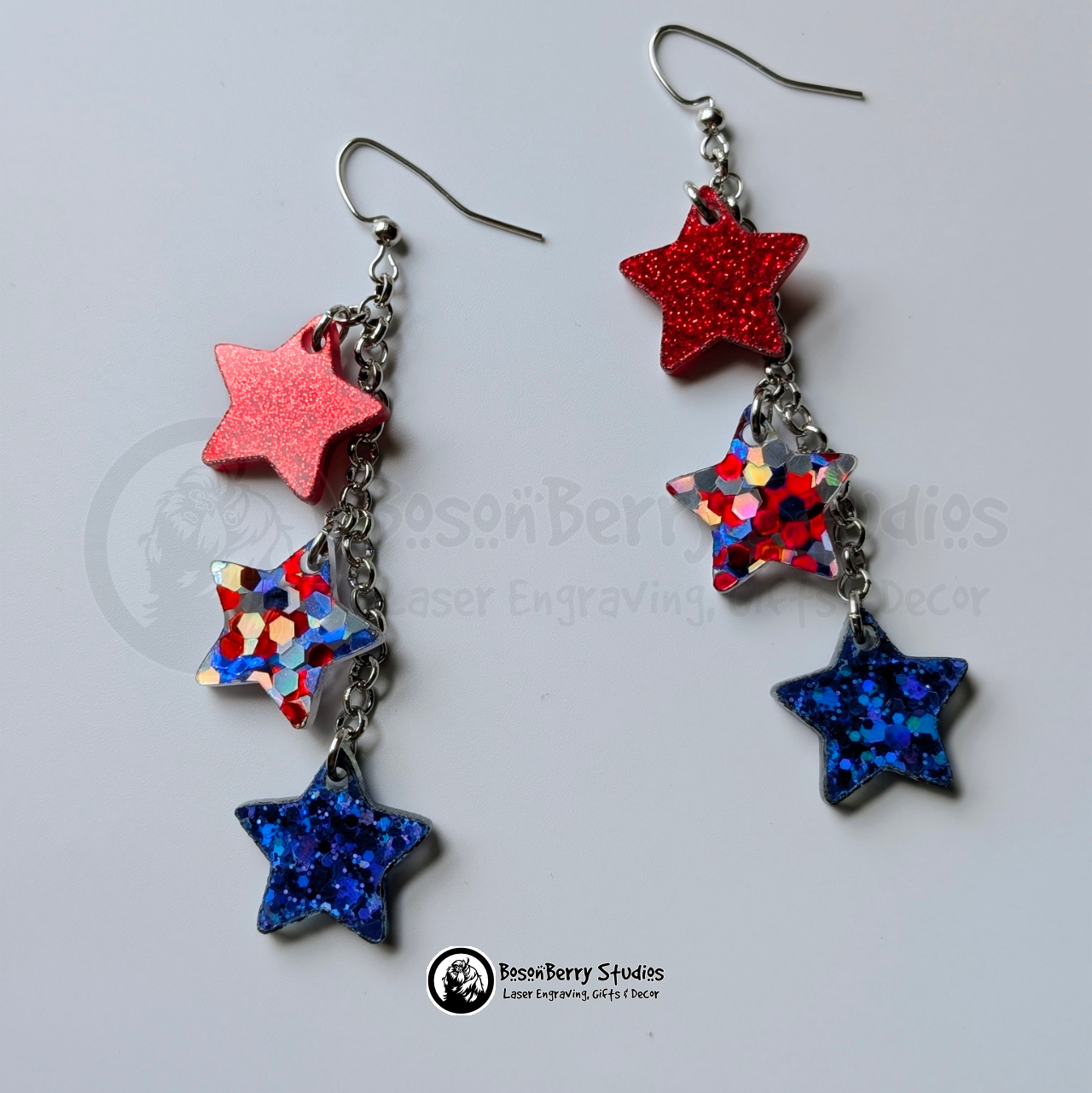 Star-shaped earrings in red, red-silver-blue, and blue on a white background with "BosonBerry Studios" branding.