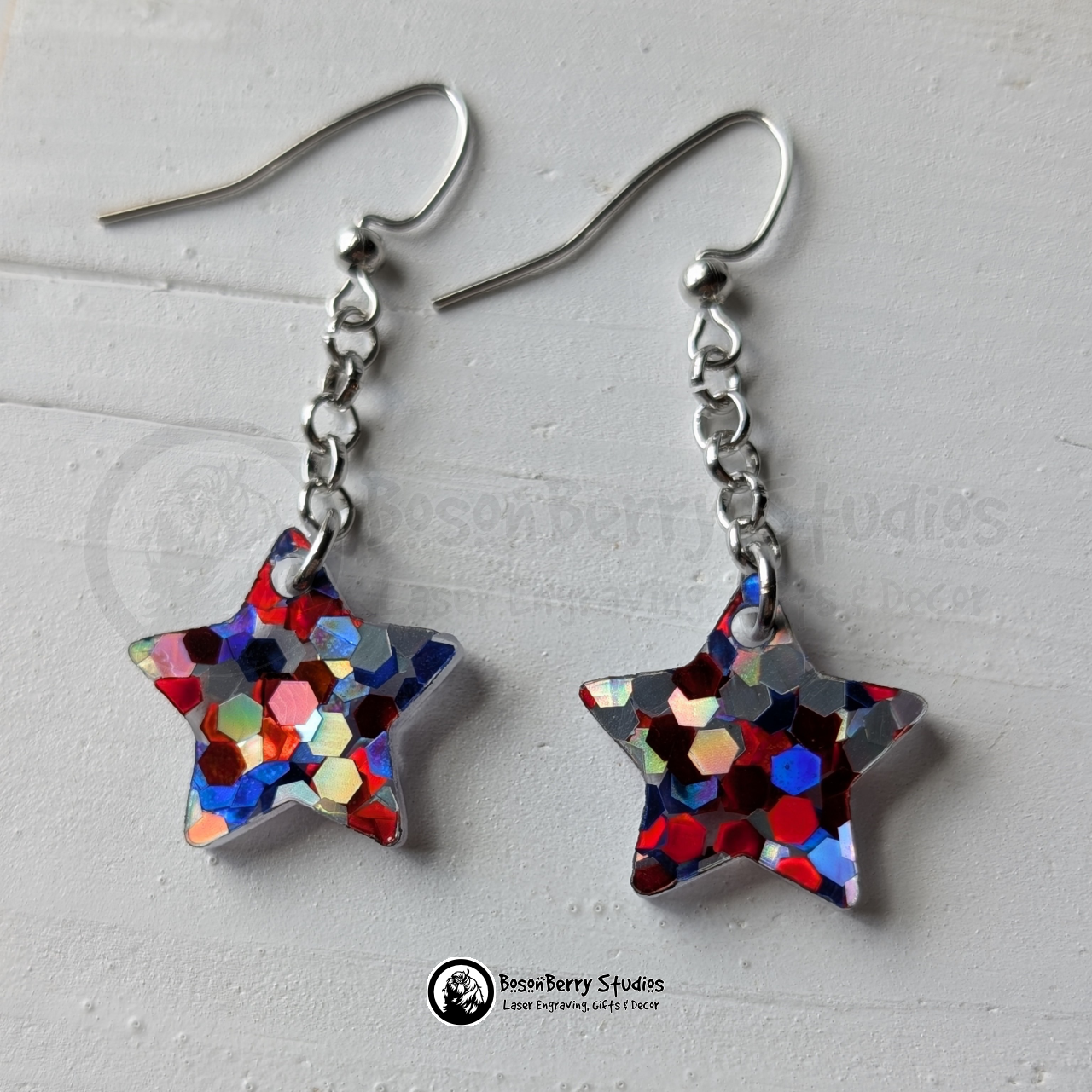 Red-silver-blue star-shaped glitter dangle earrings on a white background with "BosonBerry Studios" branding.
