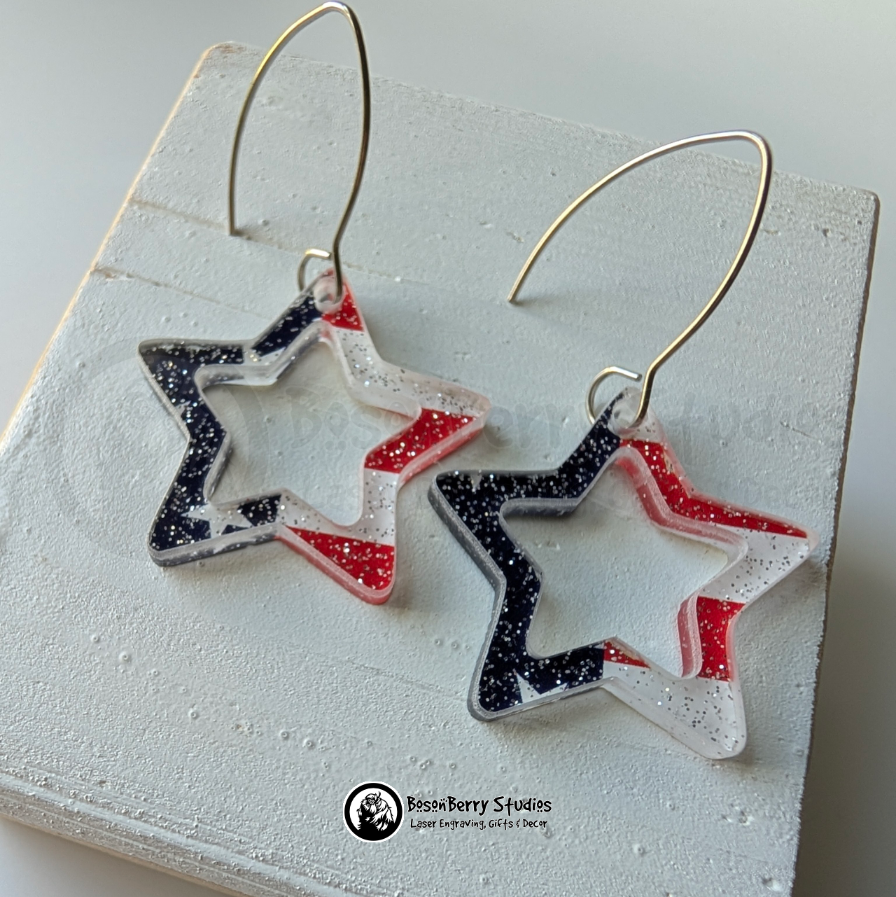 Star-shaped US Flag glitter earrings on a white background, branded 'BosonBerry Studios'.
