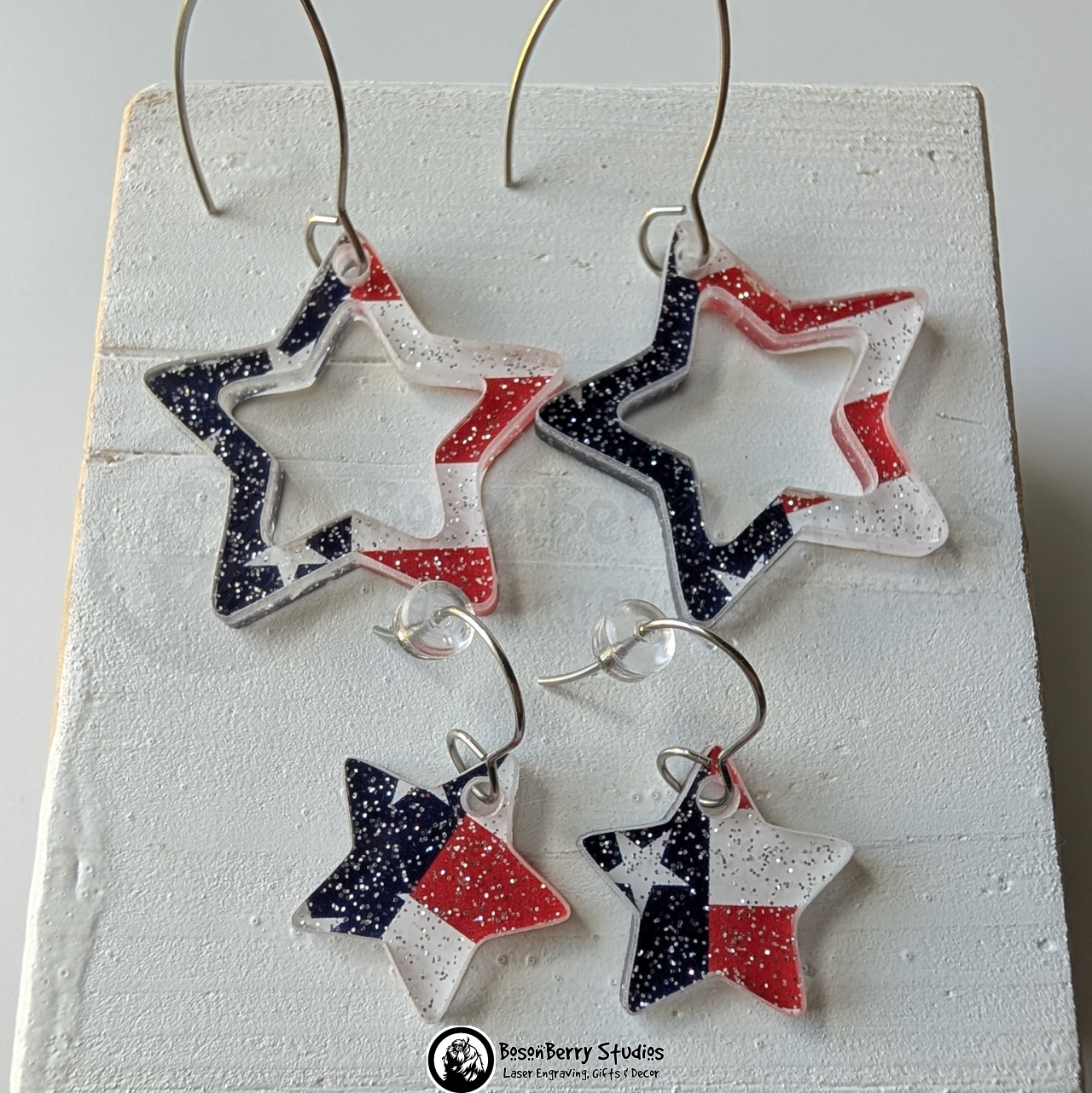 Star-shaped US Flag glitter earrings on a white background, branded 'BosonBerry Studios'.