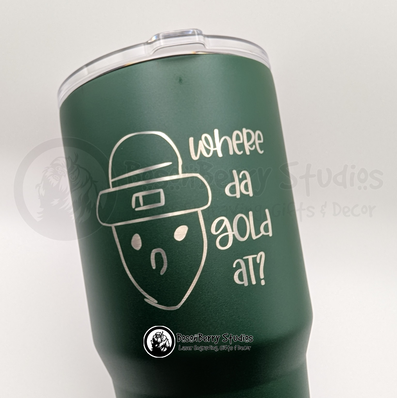 Green travel mug engraved with the Crichton Leprechaun and text on a white background