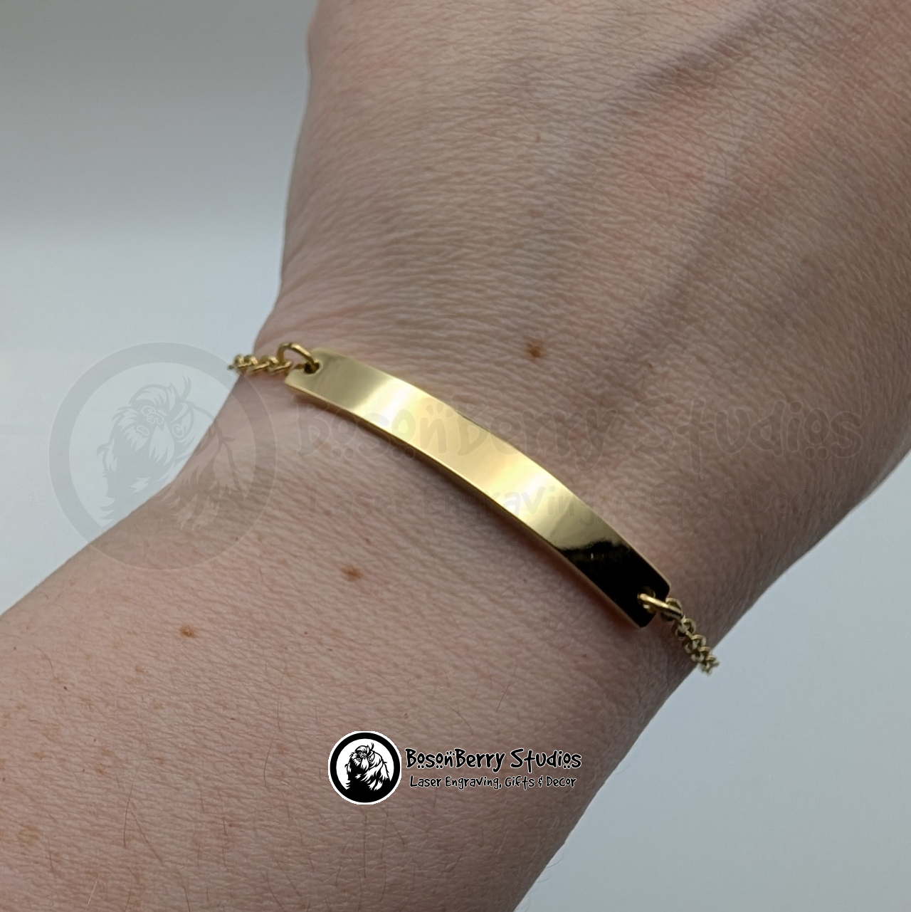 Gold bar bracelet on a wrist with a white background and 'BosonBerry Studios' branding.