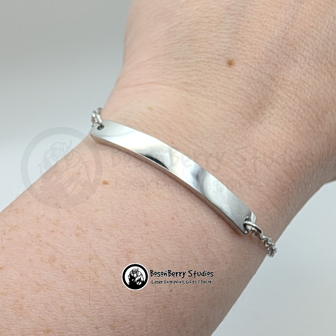 Silver bar bracelet on a wrist with a white background and 'BosonBerry Studios' branding.